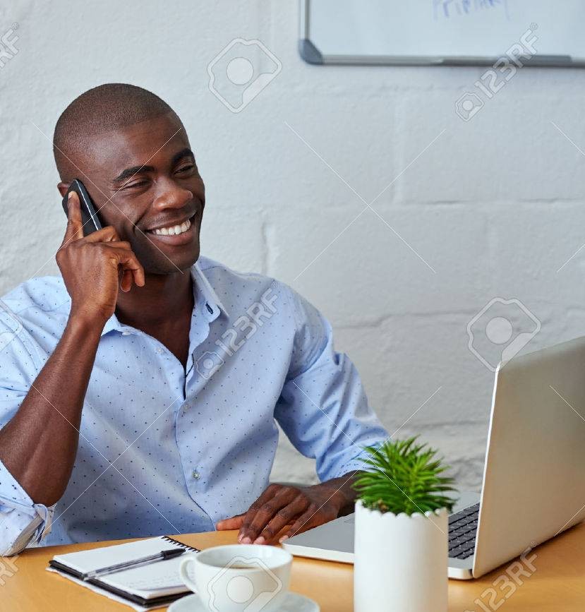 45973804-professionnel-africain-homme-noir-parlant-au-téléphone-cellulaire-mobile-pour-les-clients-dans-le ne homme au téléphone assis à son bureau