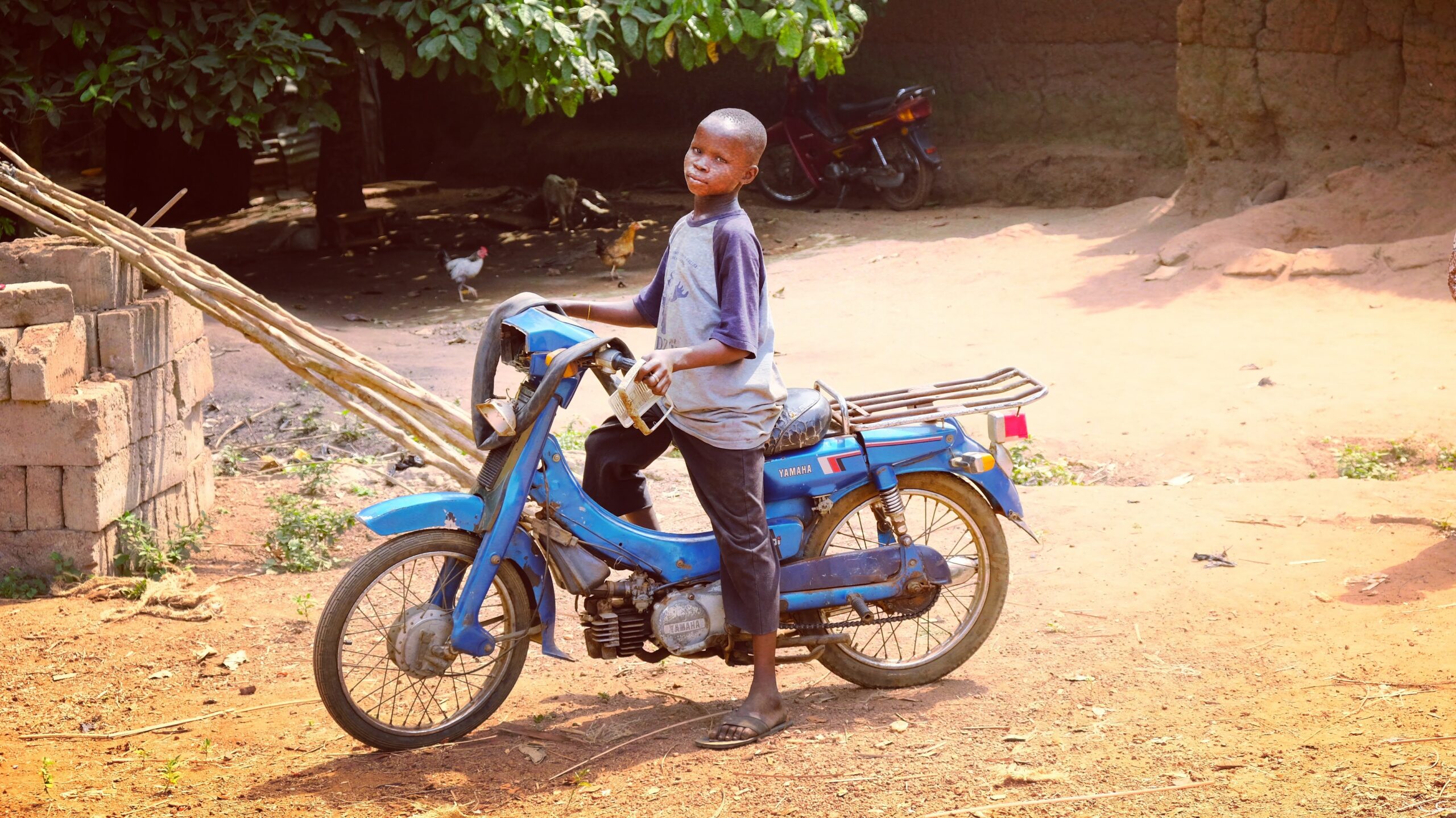 un jeune enfant bénénoir sur une mobylette