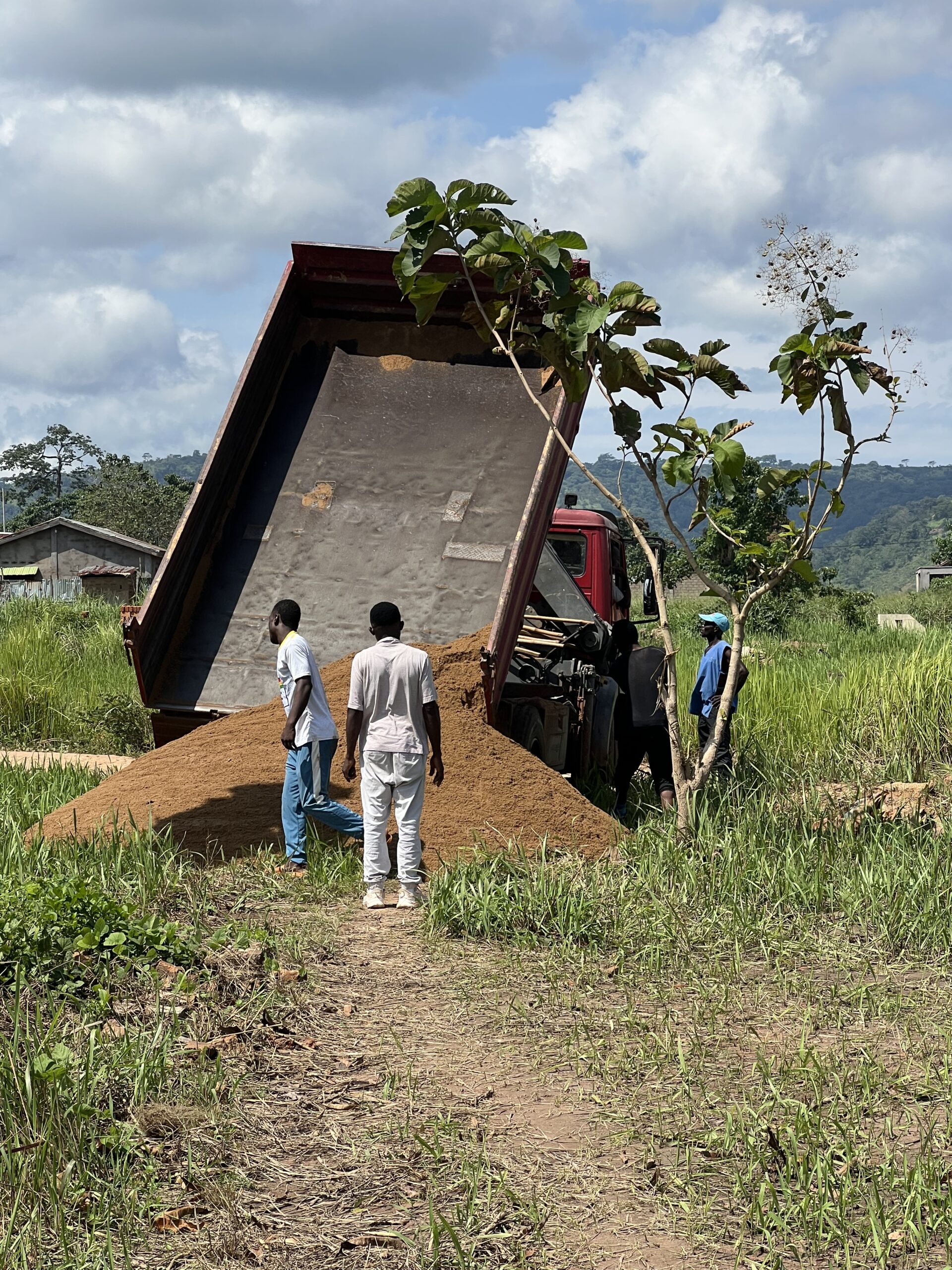 un camion benne en train de déposer du sable pour la construction BTP