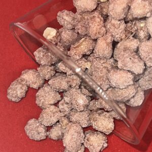 arachides enrobées de sucre versé d'un verre sur un tapis rouge