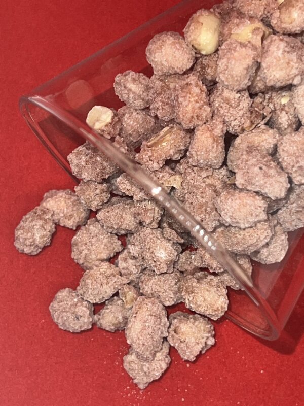 arachides enrobées de sucre versé d'un verre sur un tapis rouge