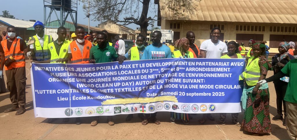 Des membres des associations présente alignée derrière un drapeau présentant toutes les associations locales et internationales présente;